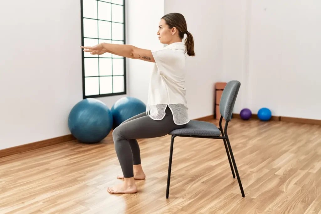 Alumna realizando ejercicio básico sobre silla de Pilates en un estudio profesional de La Zubia.